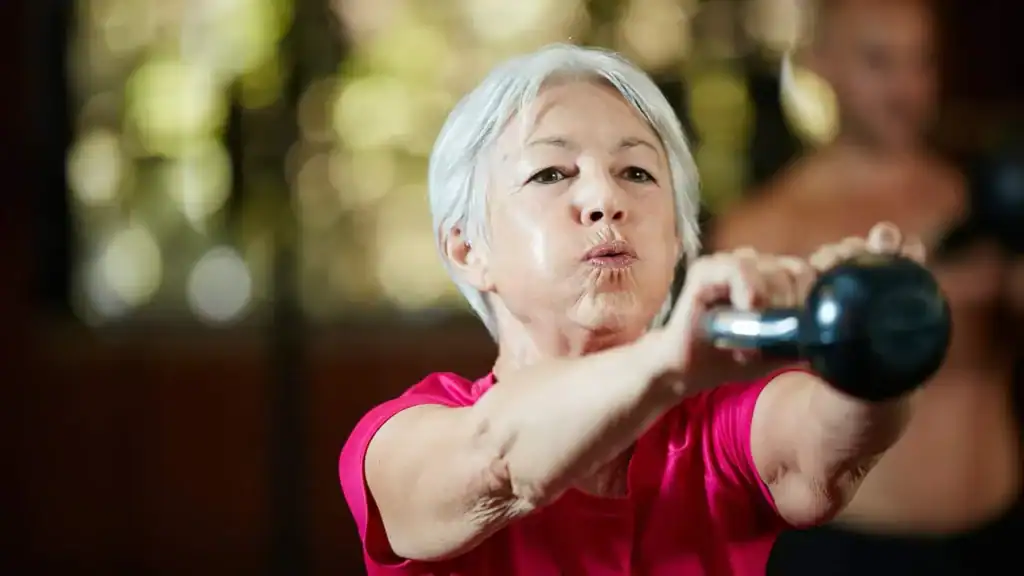 Toning Arms After 60: Empowering Womens Fitness Through Effective Weight Training 1 Older woman doing weight training Twickenham to help her strength and longevity