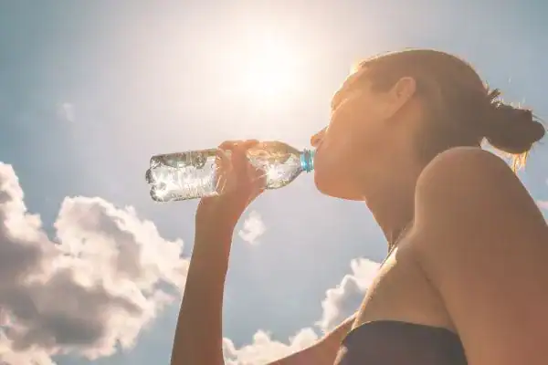 Hydration: The Secret Ingredient for a Toned Stomach and Enhanced Fitness 3 Image of woman drinking water to hydrate Twickenham after run.