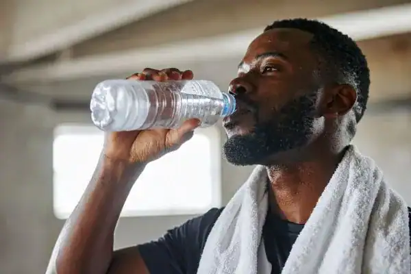Hydration: The Secret Ingredient for a Toned Stomach and Enhanced Fitness 1 Image of man drinking water to improve hydration Twickenham after work out.